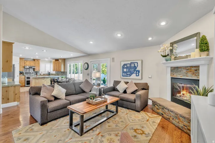 Spacious living area with vaulted ceilings and wood-finish flooring