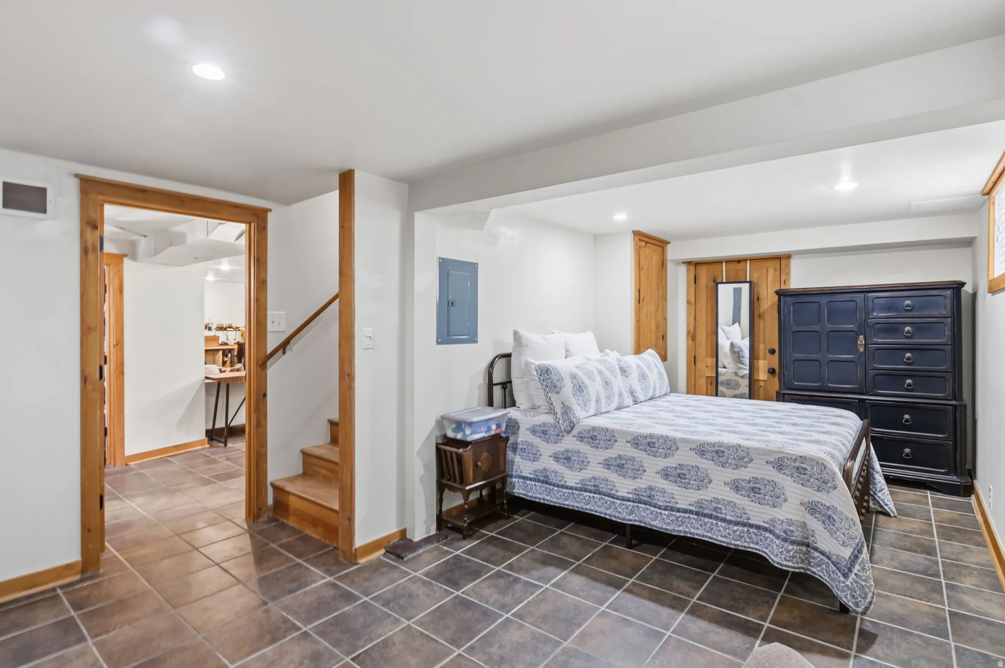 Bedroom! Tile flooring, recessed lighting, wood-finish trim, and a built-in staircase
