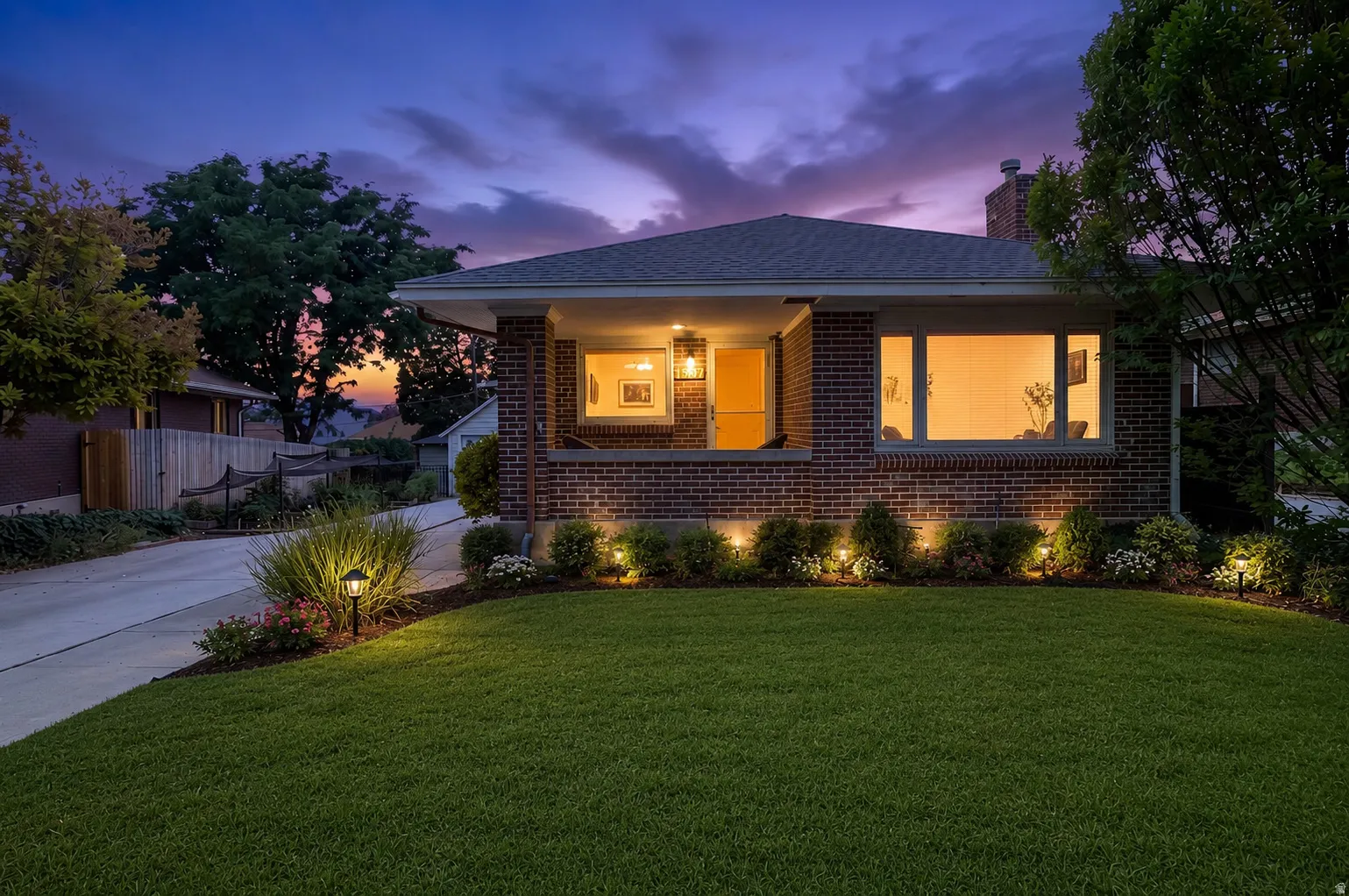 AI-Enhanced curb appeal photo. Brick exterior with a covered front porch and exterior lighting