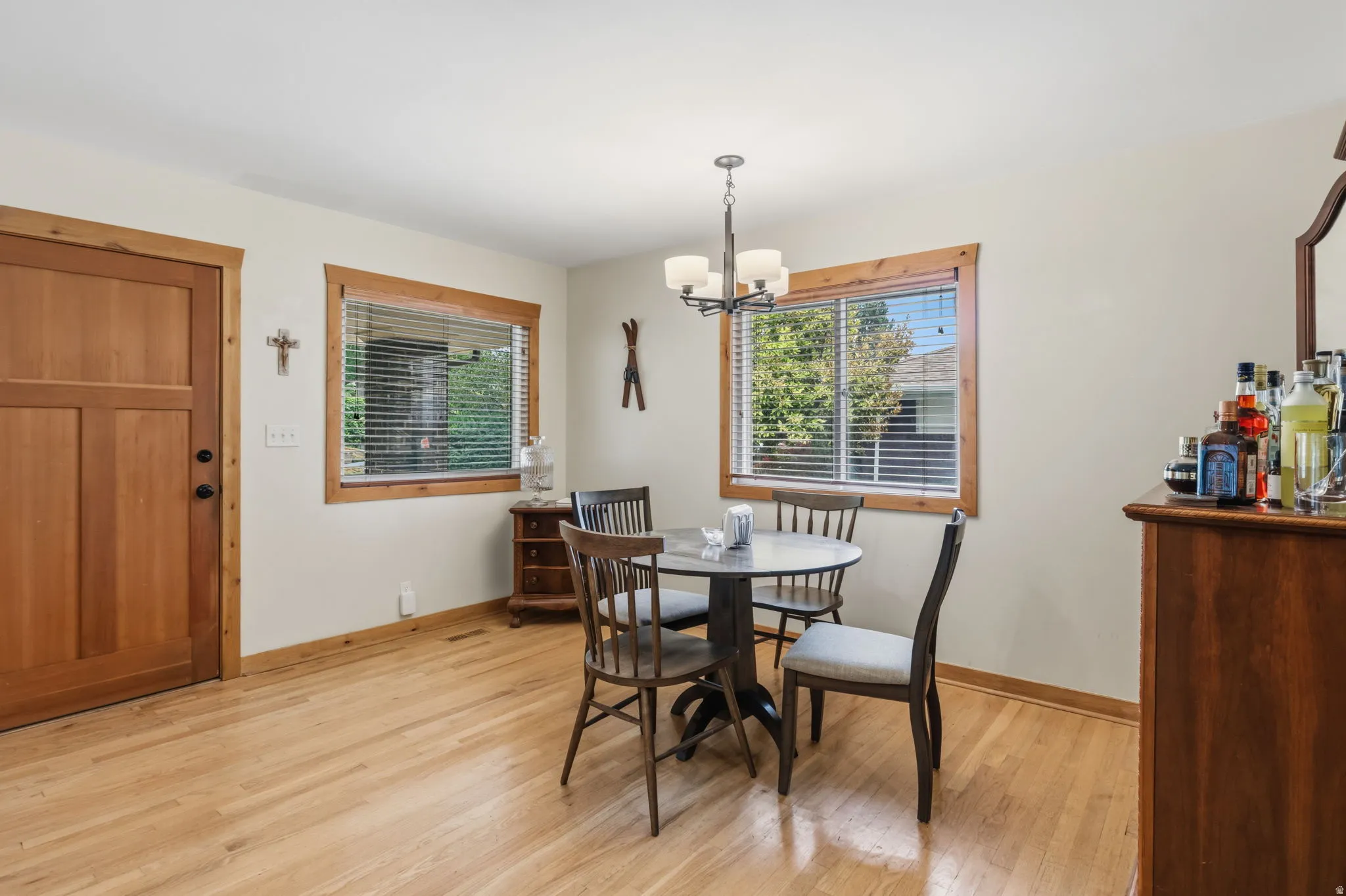 Wood-finish flooring throughout, light-toned walls, and wood-framed windows with blinds