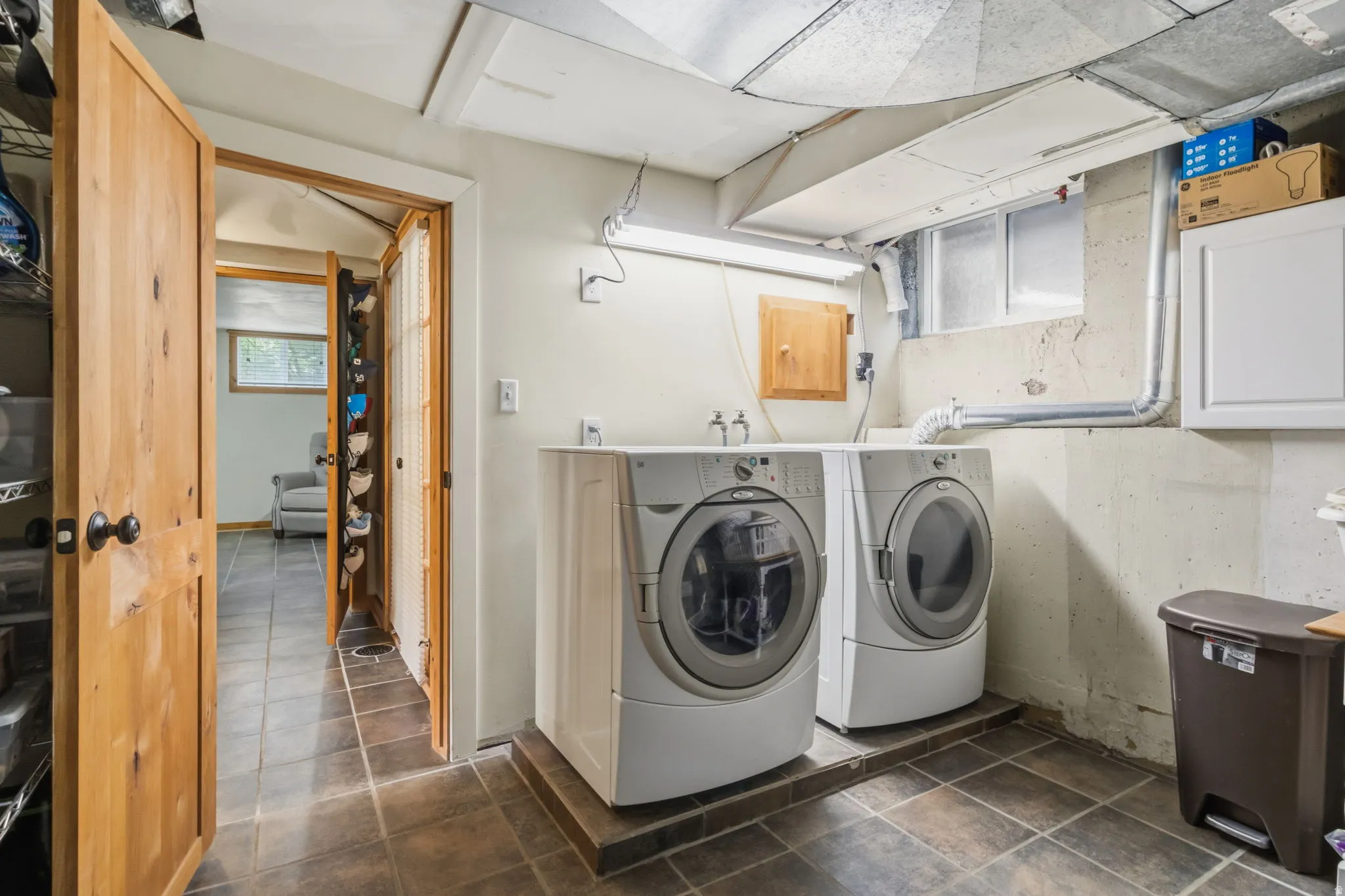 Tile flooring with contrasting grout, recessed window, and exposed ductwork