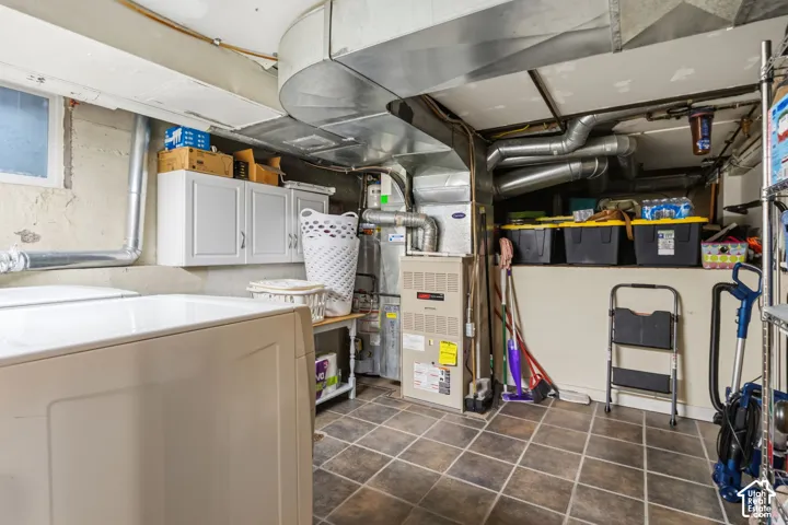 Laundry with basement shelf for storage. Utility space featuring ceramic tile flooring, built-in white cabinetry, a utility sink, and HVAC system
