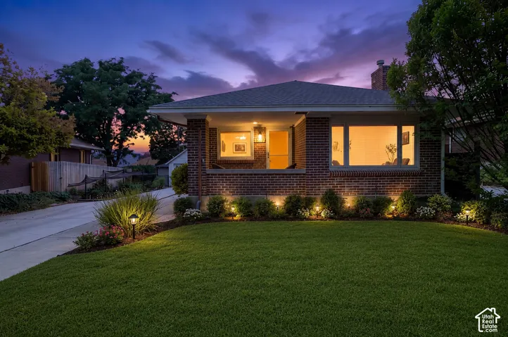 AI-Enhanced curb appeal photo. Brick exterior with a covered front porch and exterior lighting