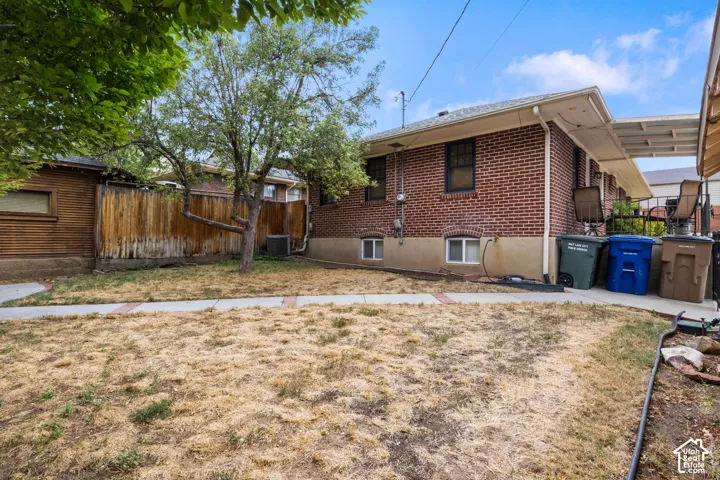Brick exterior, mature trees, wood fencing, covered patio, paved walkway