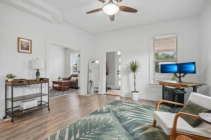 Recessed ceiling features, wood-finish flooring, ceiling fan with integrated lighting, white trim work, and a window with blinds
