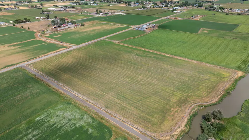 Expansive agricultural land featuring a waterway at the property edge