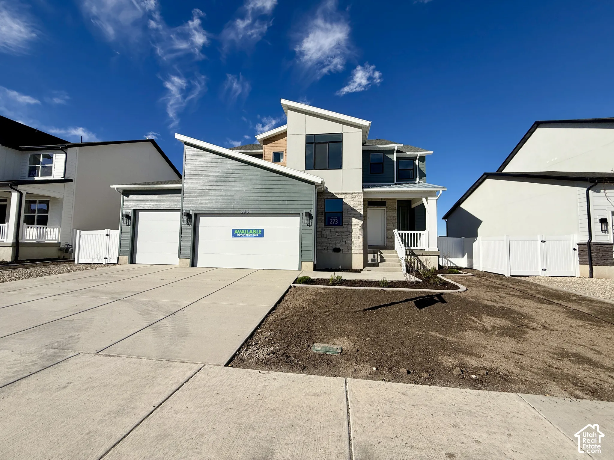 Contemporary exterior featuring a shed roofline, mixed siding, stone veneer accents, and a three-car garage
