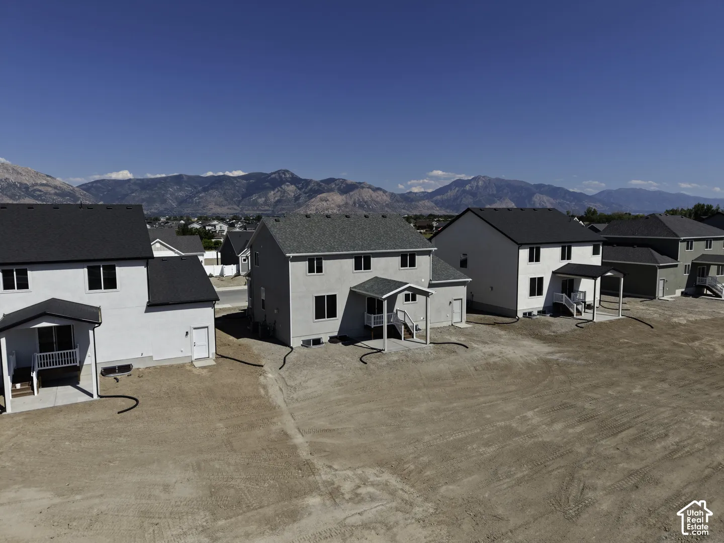 New construction residence with a covered patio, two-story design, and mountain backdrop