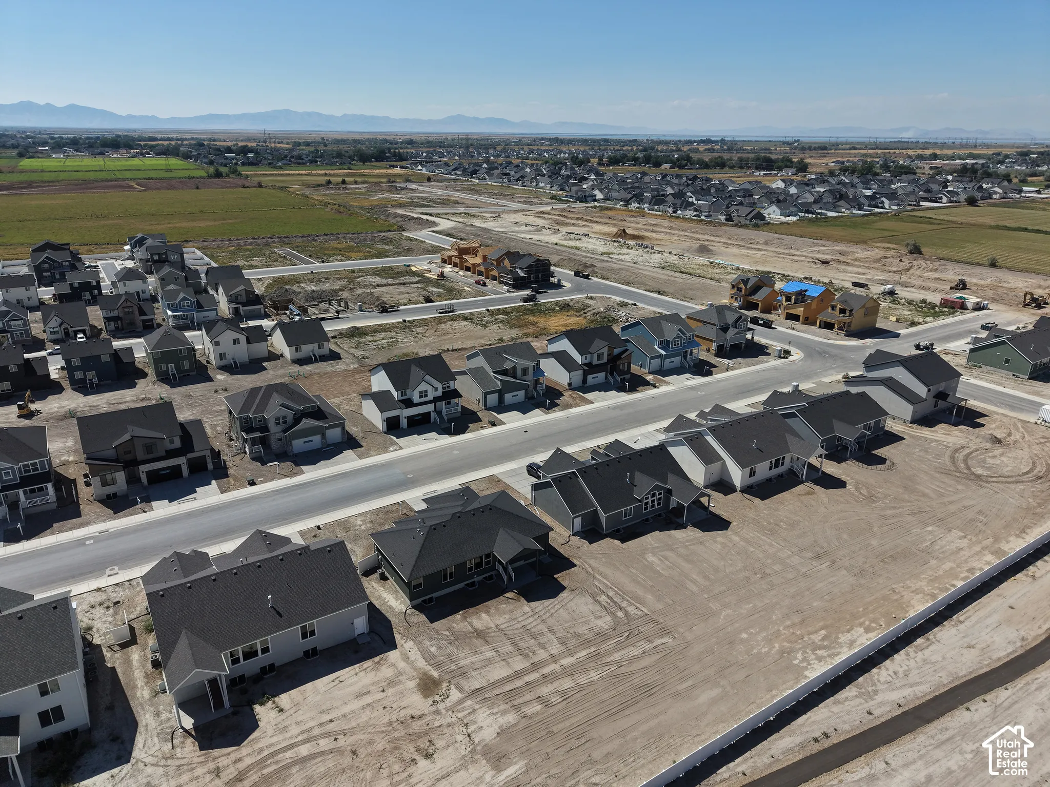 Newly constructed residential community featuring a variety of architectural styles, paved streets, and mountain backdrops