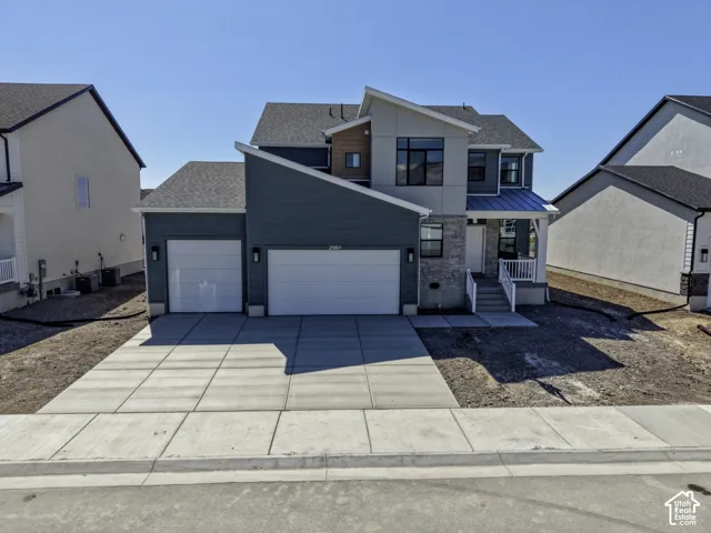 Modern two-story home featuring a dark gray and light gray exterior with multiple gabled rooflines and architectural interest