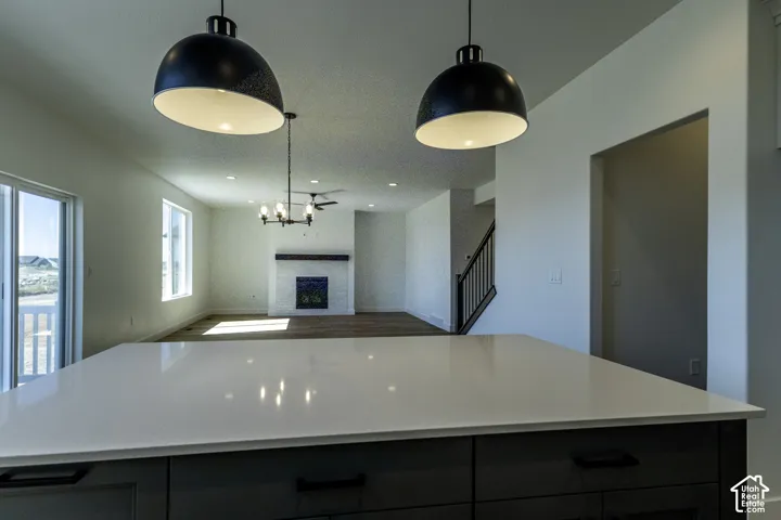 Kitchen island with a light-toned countertop, gray cabinetry, and dark hardware