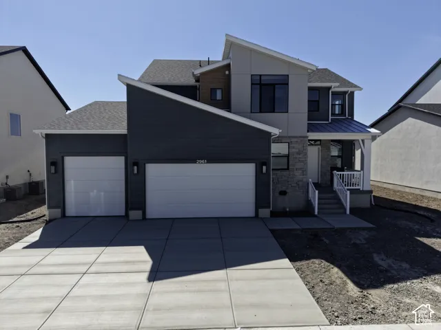 Modern architectural design with a multi-textured facade, two-car garage, and a covered porch entry