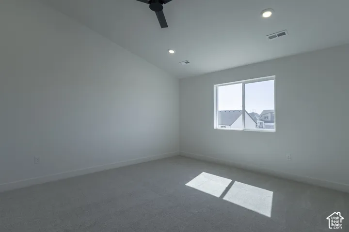 Bright, light-filled bedroom featuring recessed ceiling lighting, a ceiling fan, and large dual-pane windows framing natural light
