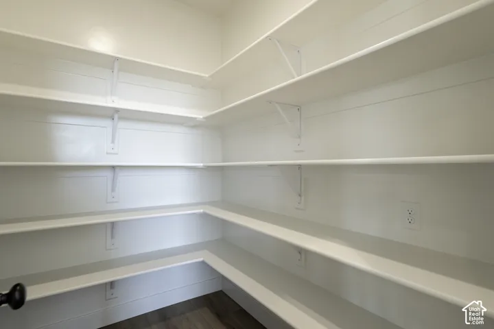 Built-in shelving with multiple storage tiers, corner shelving configuration, and wood-finish flooring
