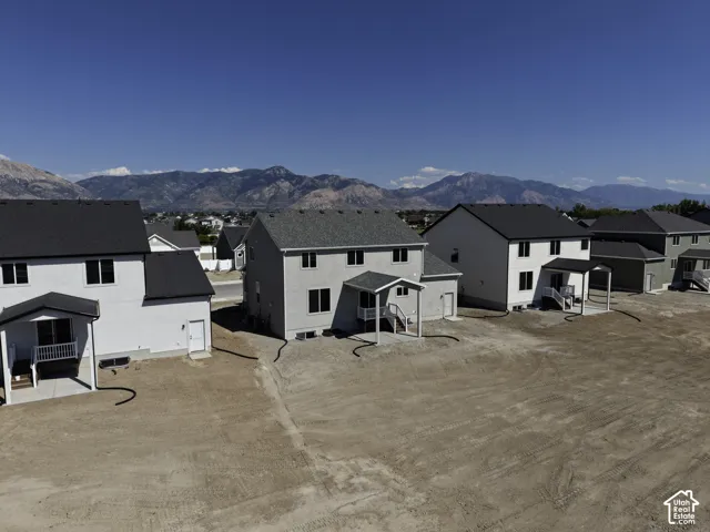New construction residence with a covered patio, two-story design, and mountain backdrop