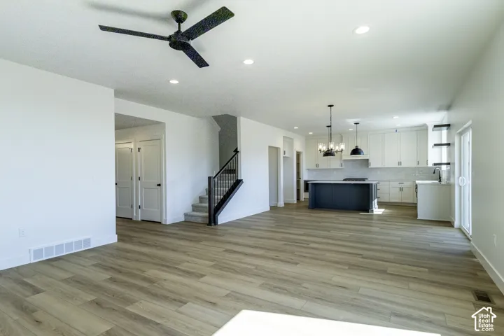 Open-concept living space featuring wide-plank wood-finish flooring, recessed lighting, and a ceiling fan