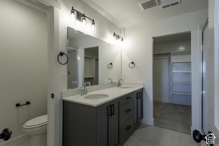 Dual vanity with gray cabinetry, white countertops, and brushed nickel fixtures