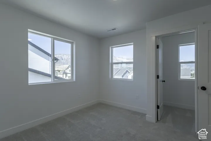 Carpeted interior with multiple windows, recessed lighting, and white trim