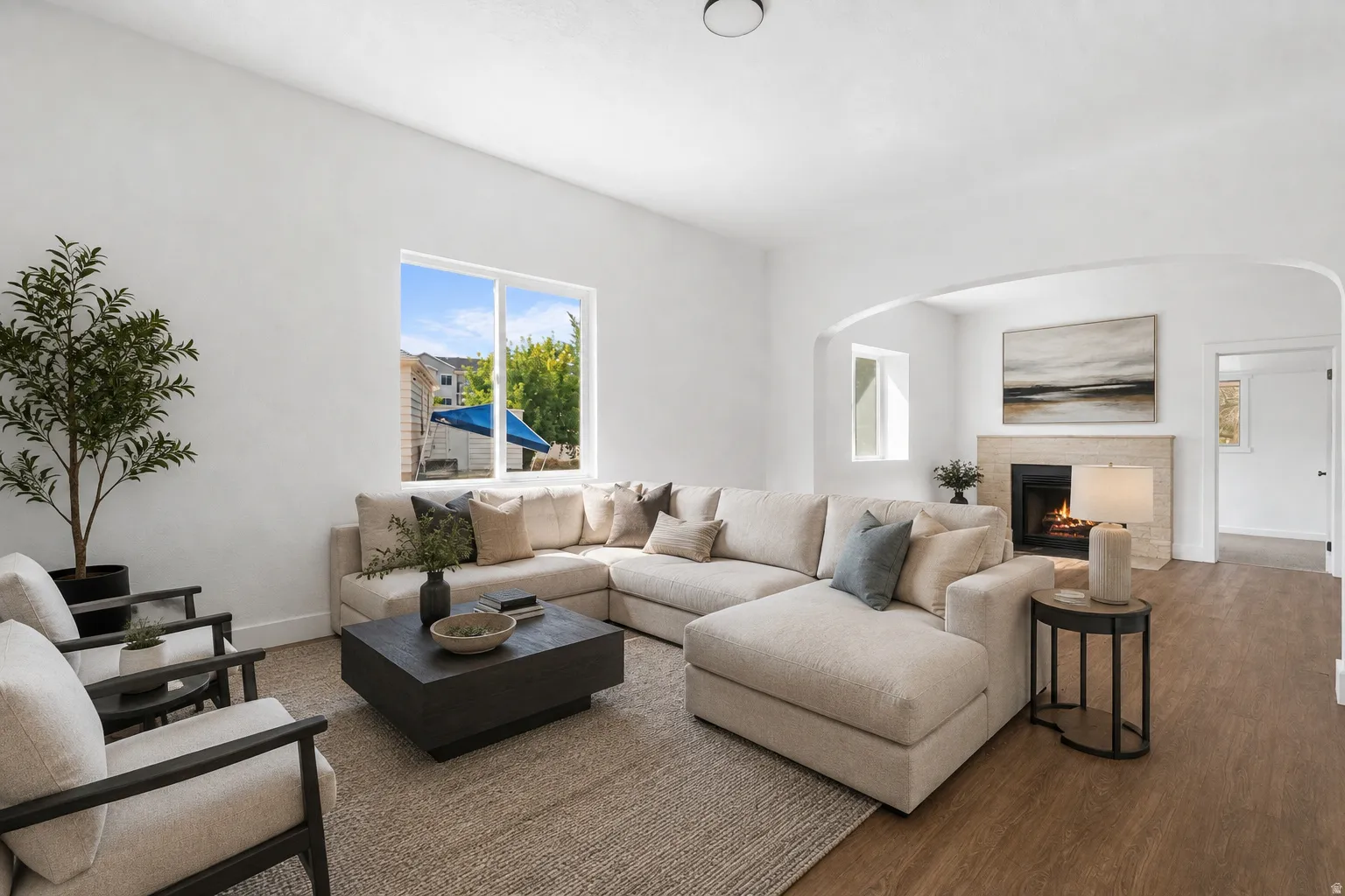 Virtual Staged. Recessed ceiling lighting, neutral wall finishes, a stone-clad fireplace with hearth, and wood-finish flooring