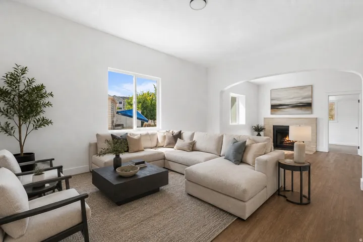 Virtual Staged. Recessed ceiling lighting, neutral wall finishes, a stone-clad fireplace with hearth, and wood-finish flooring