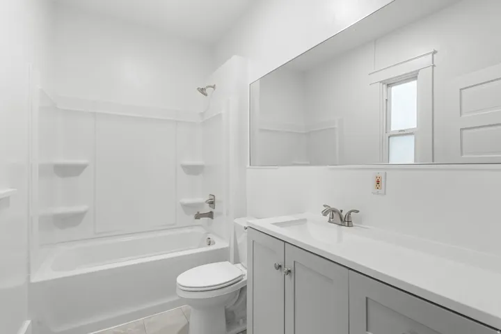 White bathtub/shower combination with integrated shelving