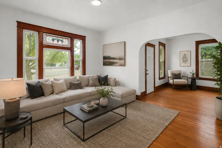 Virtual Staged. Warm wood-finish flooring, white walls, and an arched entry characterize this space