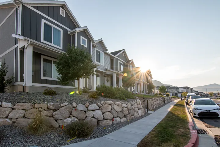Townhome featuring vertical panel siding and white trim accents