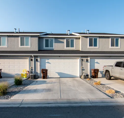 Two-story exterior with stucco siding and multiple white-framed windows