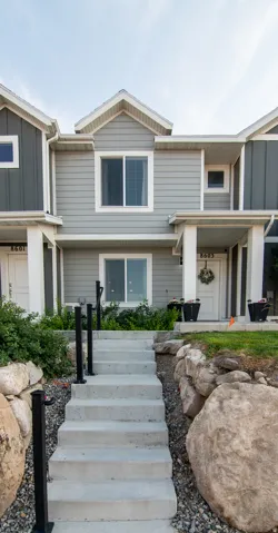 Contemporary facade with light gray siding, white trim, and a covered porch entry