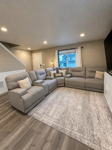 Recessed lighting, wood-finish flooring, white trim, and a window with a white frame