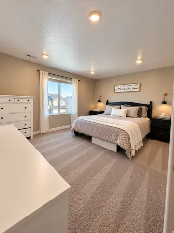 Wall-to-wall carpeting with an integrated window, recessed ceiling lighting, and wall-mounted light fixtures