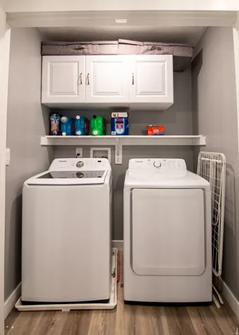 Built-in white cabinetry, open shelving, and wood-finish flooring