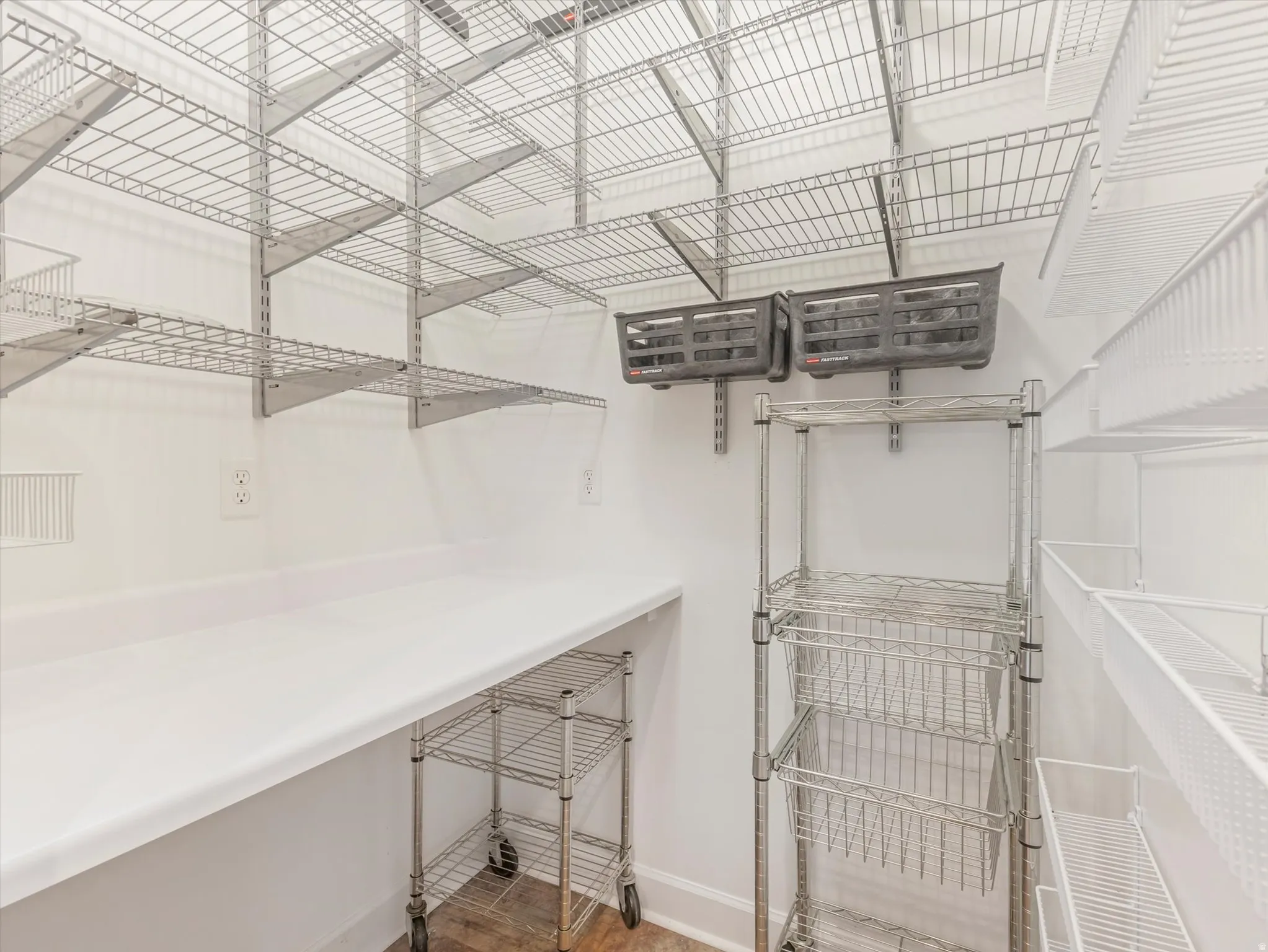 White countertop with ample surface area, multiple power outlets, and extensive wire shelving