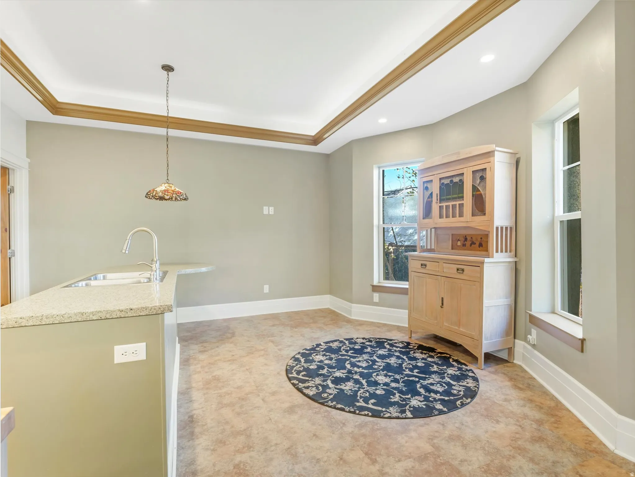 Kitchen area with a granite-style countertop, undermount sink, and gooseneck faucet