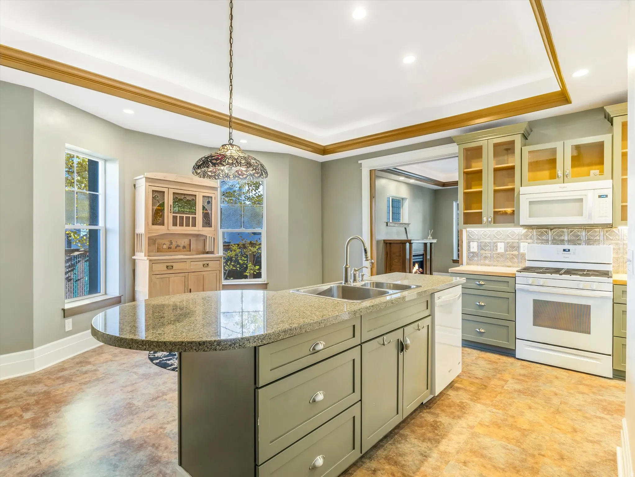 Kitchen featuring an island with a built-in sink, granite countertops, and recessed lighting
