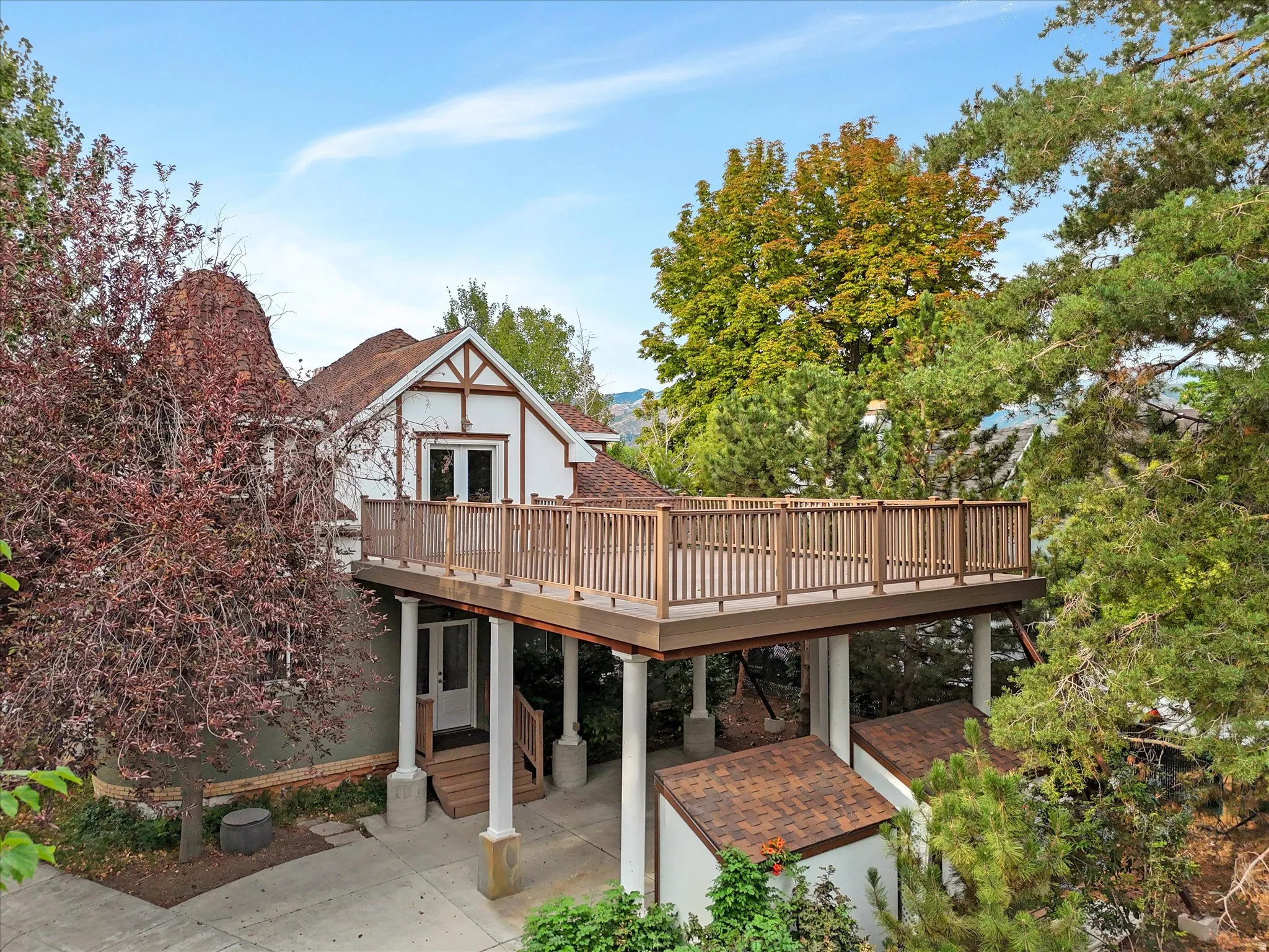 Brand new elevated deck with wood railing, supported by architectural columns