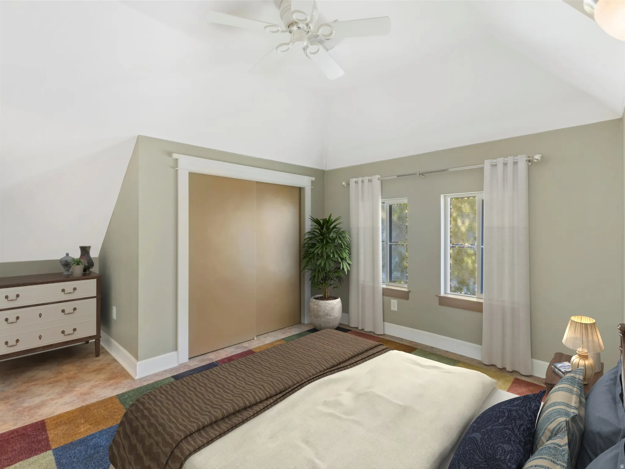 Vaulted ceiling with a ceiling fan, two windows, and a built-in closet with sliding doors