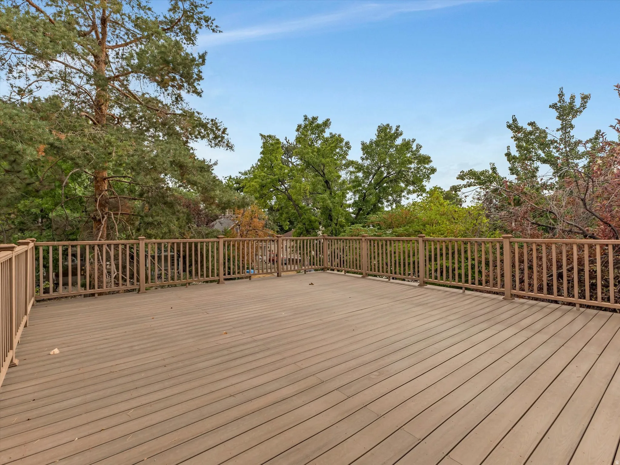 Expansive brand new deck with wood-finish decking and perimeter railing