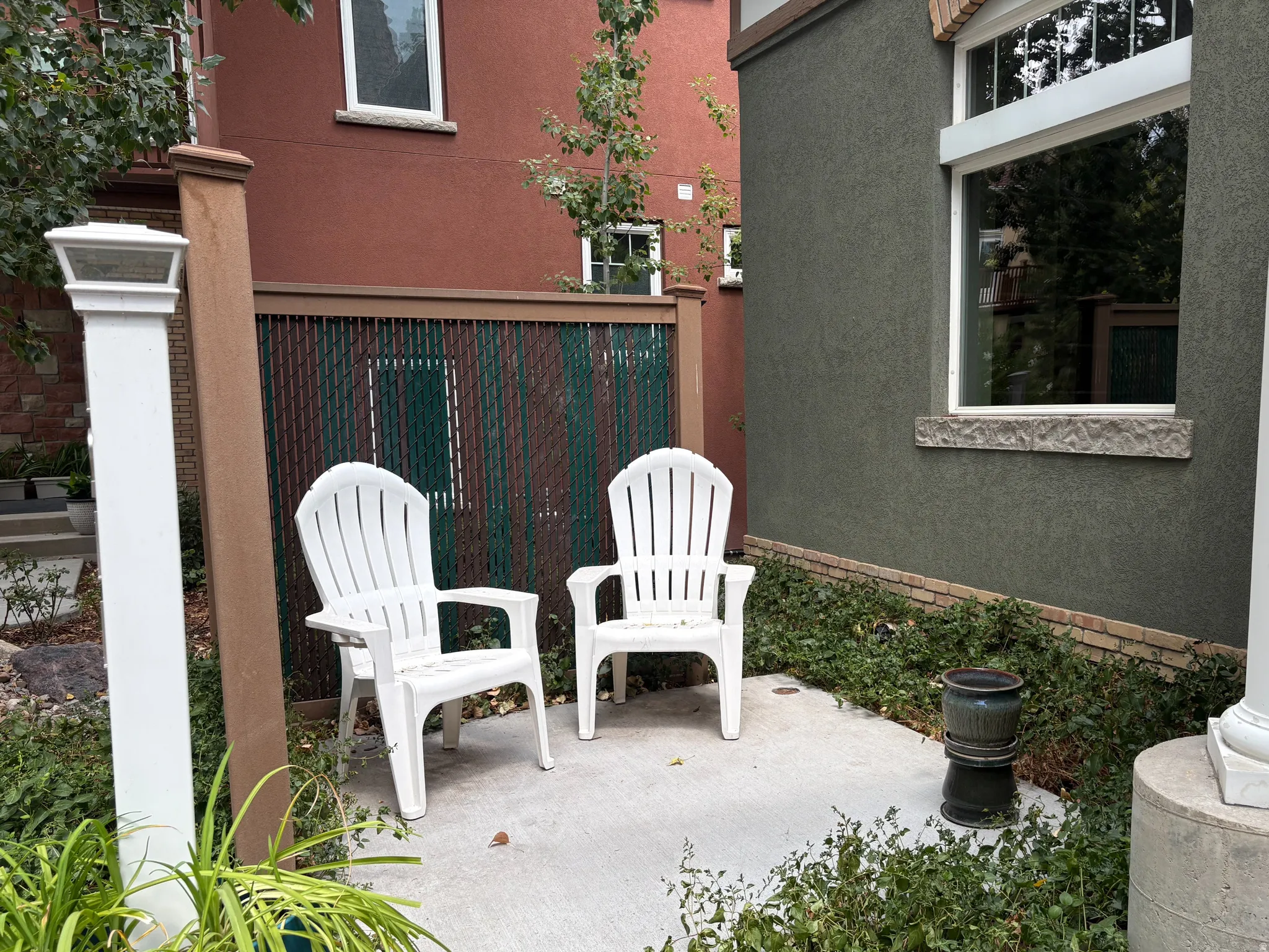 Concrete patio area featuring a privacy fence and stucco exterior