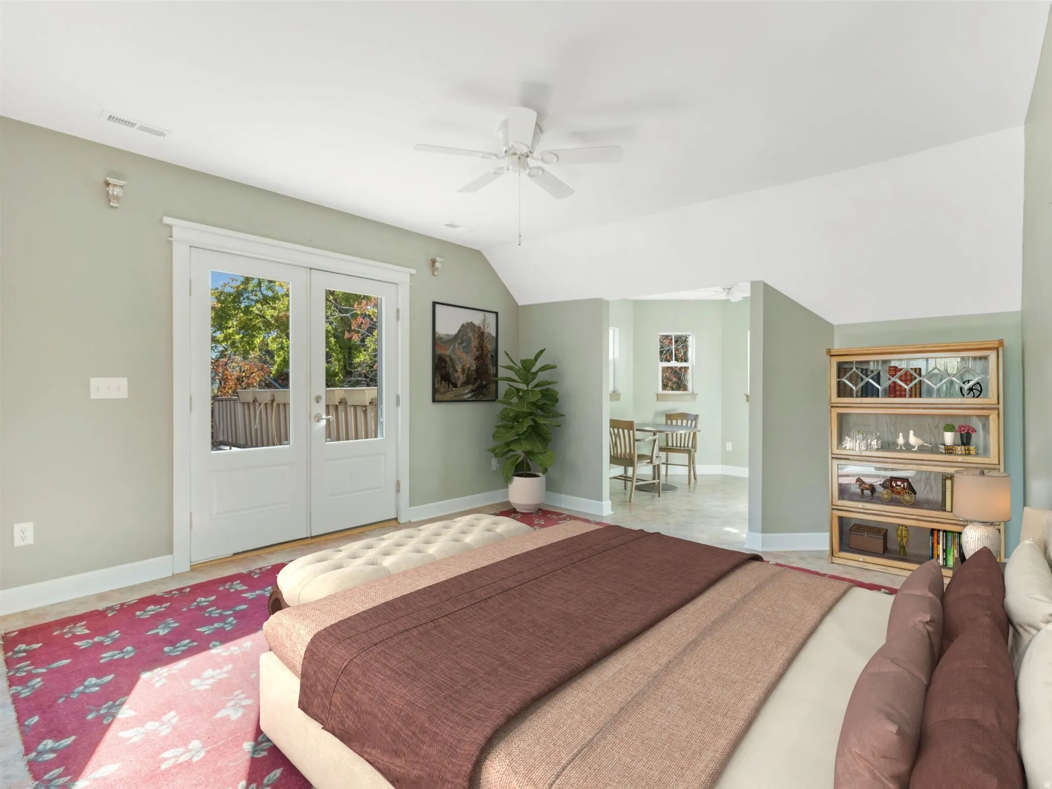 Vaulted ceiling with a ceiling fan, French doors, wood-finish flooring, built-in shelving, and light-toned walls