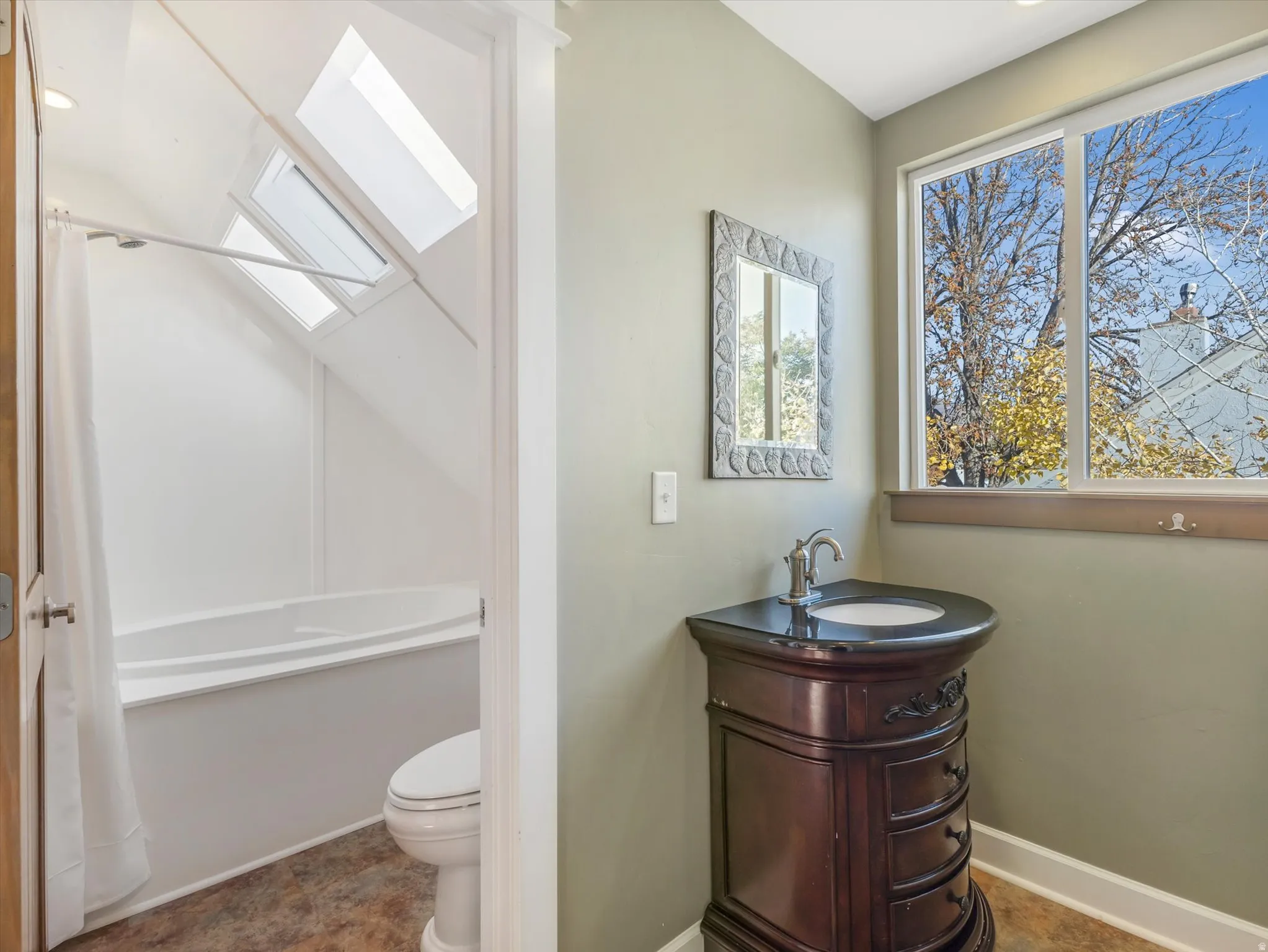 Freestanding vanity with an integrated sink, large window, and skylights