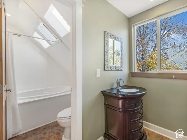 Freestanding vanity with an integrated sink, large window, and skylights