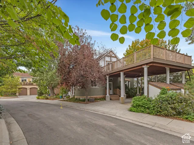 Multi-level exterior with a brand new elevated deck featuring wood railing, supported by architectural columns