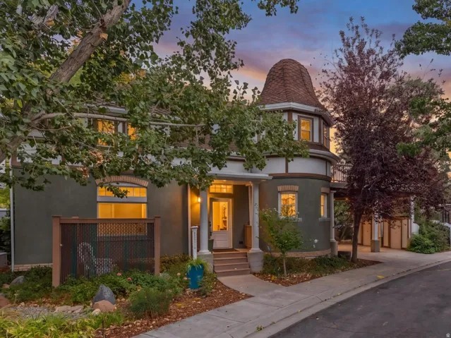 Stucco exterior with a prominent turret, covered front entry porch, and mature trees