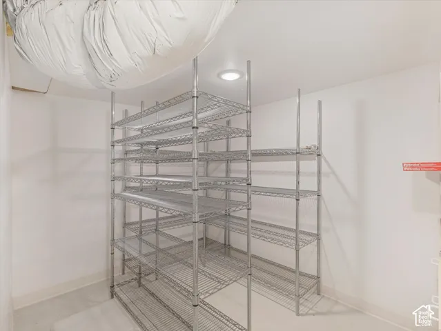 Extensive wire shelving system, recessed ceiling lighting, smooth concrete flooring, and white wall finishes
