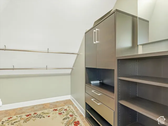 Walk-in closet, with built-in cabinetry with silver-tone hardware, adjustable shelving, and garment rods