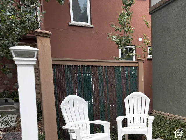 Concrete patio area featuring a privacy fence and stucco exterior