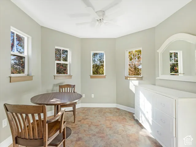 Room with multiple windows, textured flooring, and a ceiling fan