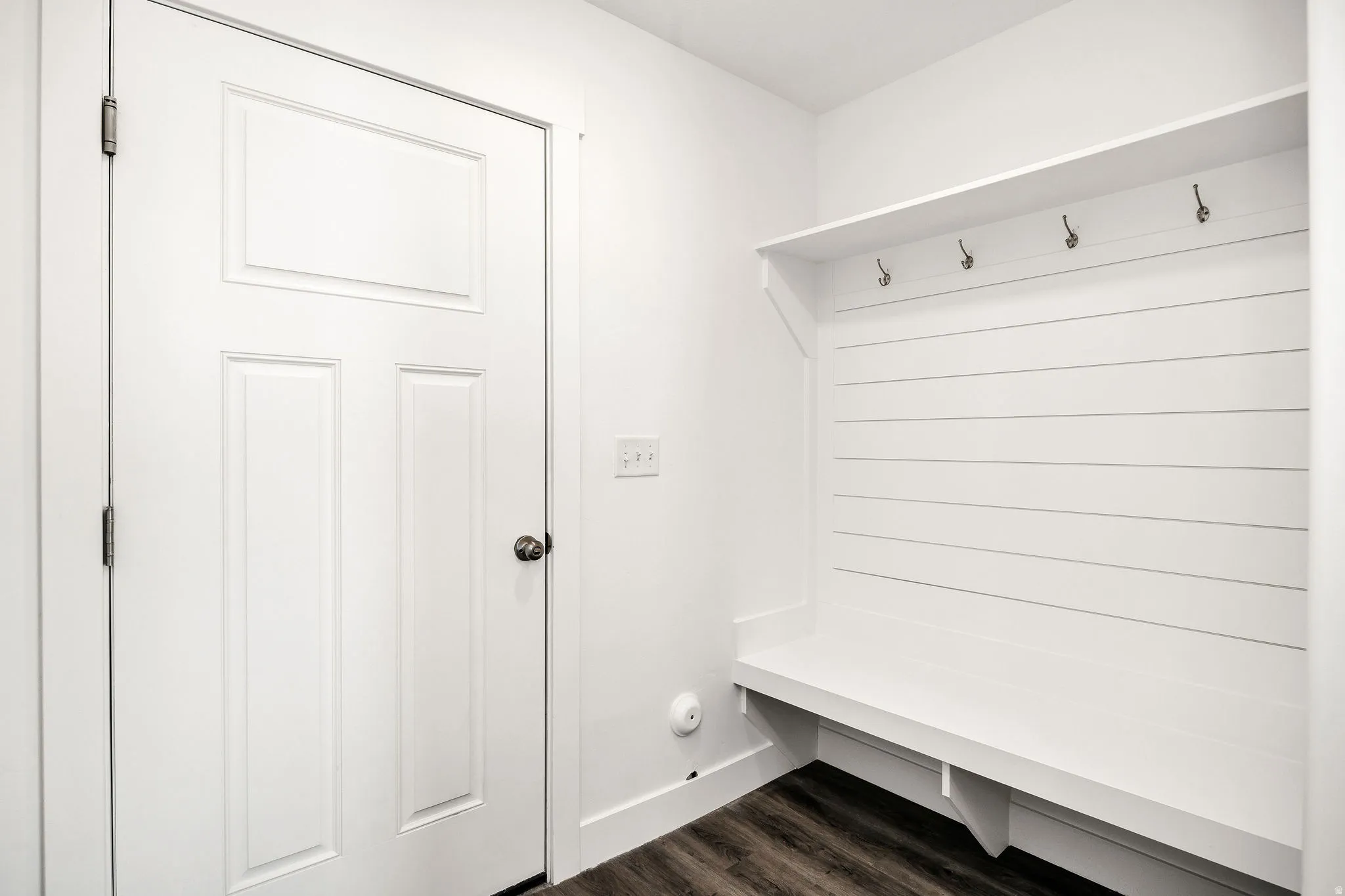 Built-in bench with shiplap backing, integrated shelving, and metal coat hooks