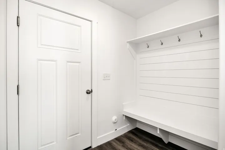 Built-in bench with shiplap backing, integrated shelving, and metal coat hooks